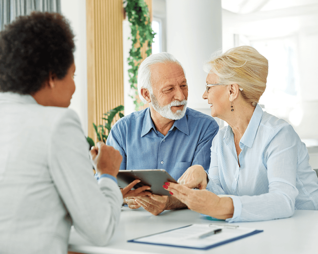 Senior couple discussing health insurance and Medicare coverage options with an advisor.